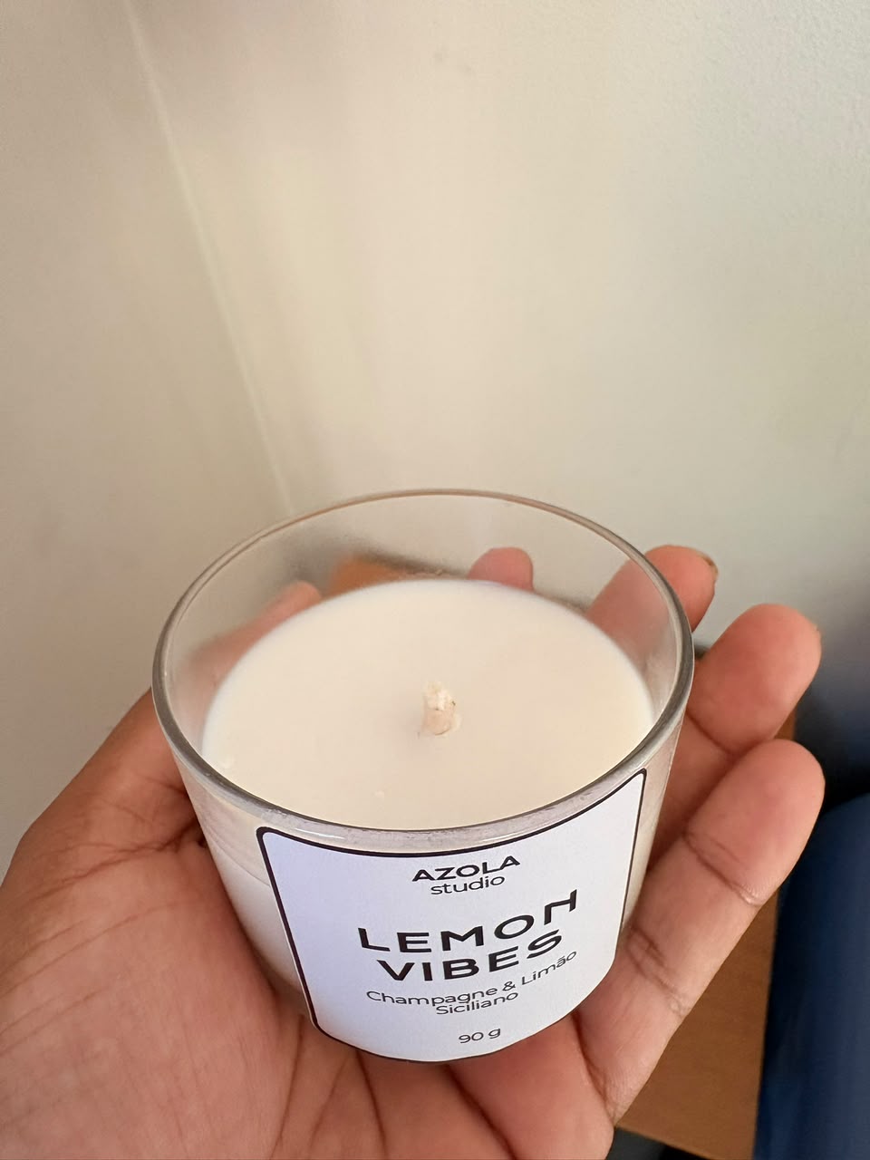 Vela Aromática Lemon Vibes em copo de vidro segurado por uma mão